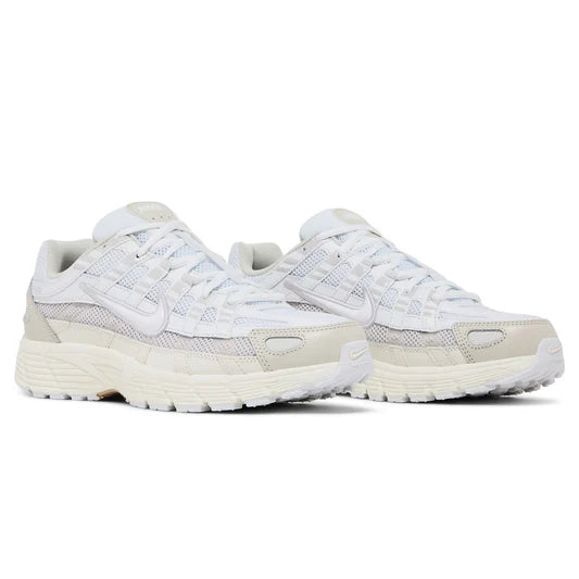 Nike P-6000 White Sail held in man's hand showing white mesh upper with sail cream synthetic overlays and vast grey accents against polished concrete background